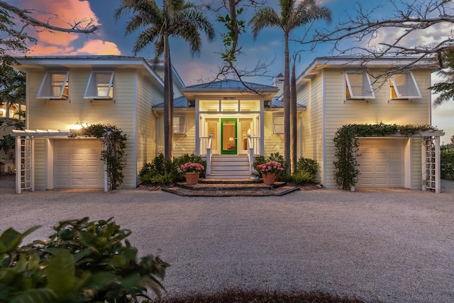 view of front of home with a garage and gravel driveway