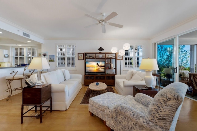 living area featuring plenty of natural light, visible vents, and ornamental molding