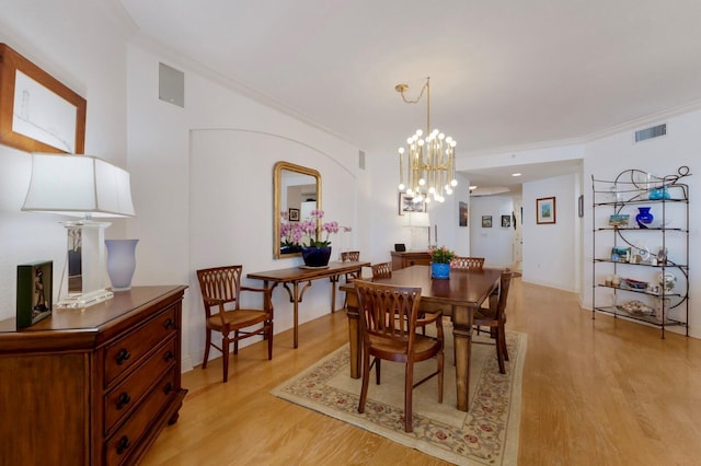 dining room featuring ornamental molding, light wood-type flooring, and visible vents