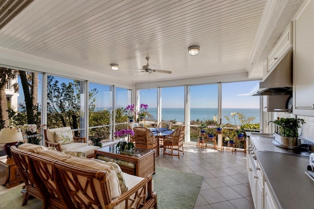 sunroom / solarium featuring a water view and ceiling fan