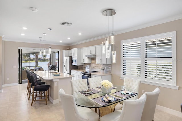 dining area with baseboards, visible vents, and crown molding