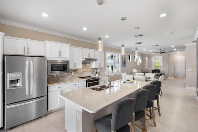 kitchen with visible vents, ornamental molding, stainless steel appliances, under cabinet range hood, and a sink