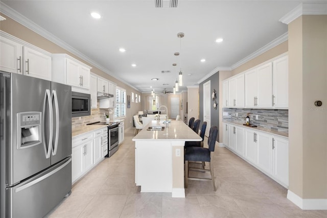 kitchen featuring light countertops, appliances with stainless steel finishes, a sink, and crown molding