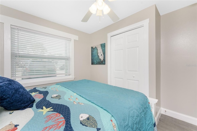 bedroom with a ceiling fan, a closet, and baseboards