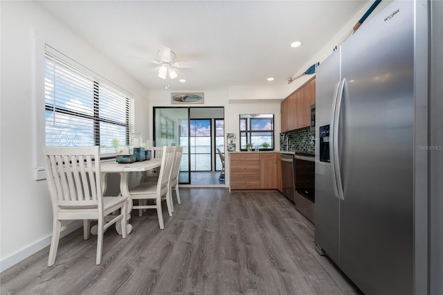 kitchen with brown cabinetry, plenty of natural light, stainless steel appliances, and wood finished floors