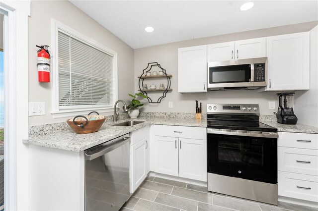 kitchen featuring stainless steel appliances, recessed lighting, a sink, and white cabinets