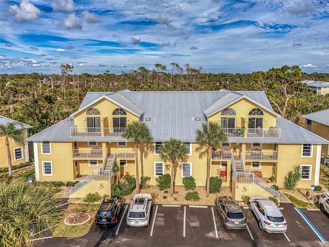 view of property featuring uncovered parking and stairway