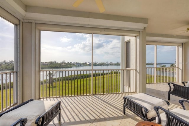 sunroom featuring a water view, plenty of natural light, and a ceiling fan