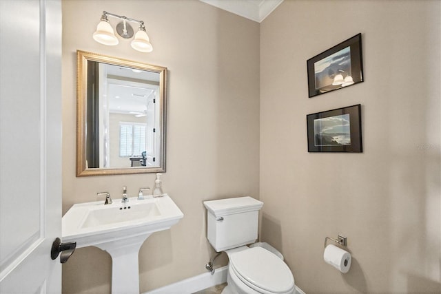 bathroom with toilet, baseboards, and a sink