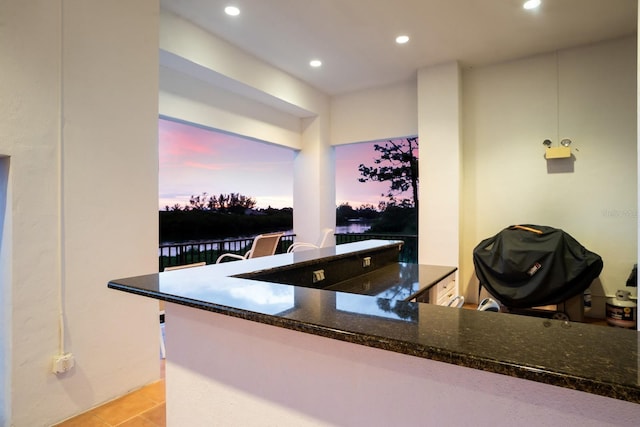 kitchen featuring recessed lighting, dark stone countertops, and light tile patterned floors