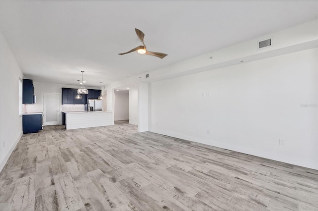 unfurnished living room featuring visible vents, ceiling fan, light wood-style flooring, and baseboards