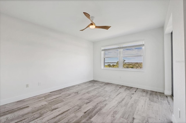 unfurnished room with ceiling fan, baseboards, and wood finished floors