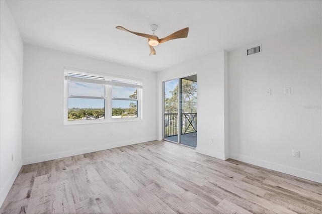 unfurnished room featuring light wood-style floors, visible vents, baseboards, and a ceiling fan