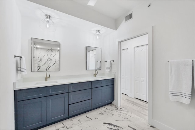 bathroom with marble finish floor, visible vents, a sink, and double vanity