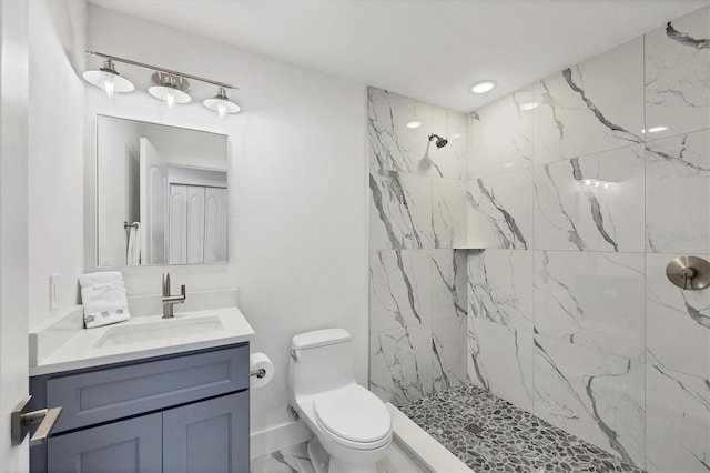 bathroom with toilet, vanity, baseboards, marble finish floor, and a marble finish shower