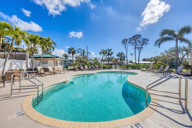 community pool with fence and a patio