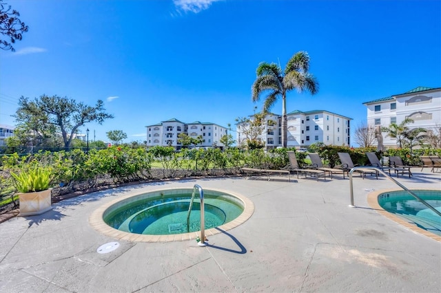 view of swimming pool featuring a community hot tub, a patio area, and a swimming pool