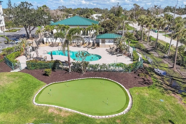 pool with a patio, a lawn, and fence