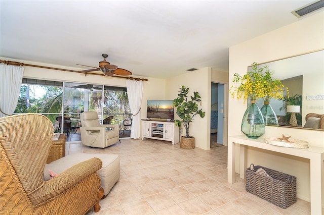 living area featuring a ceiling fan, visible vents, and light tile patterned floors