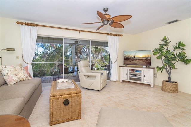 living area with a wealth of natural light, tile patterned floors, visible vents, and a ceiling fan