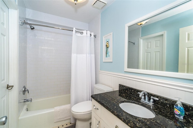 full bath with shower / bath combo with shower curtain, wainscoting, vanity, and toilet