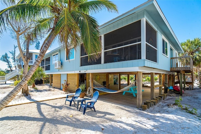 back of property with a sunroom and stairs