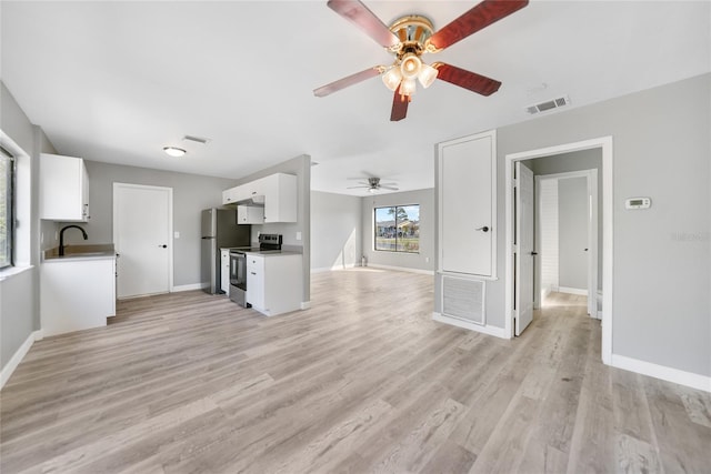 unfurnished living room featuring light wood-style flooring, visible vents, and baseboards