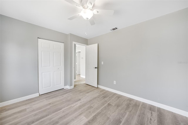 unfurnished bedroom with light wood finished floors, a closet, visible vents, and baseboards