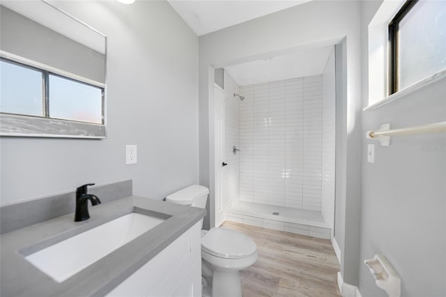 bathroom featuring vanity, wood finished floors, a shower stall, and toilet