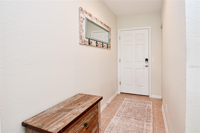 doorway with baseboards and light tile patterned floors