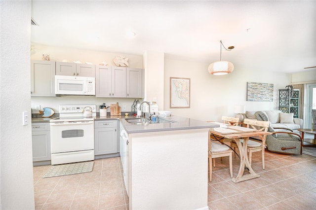 kitchen featuring light tile patterned flooring, a peninsula, white appliances, a sink, and open floor plan