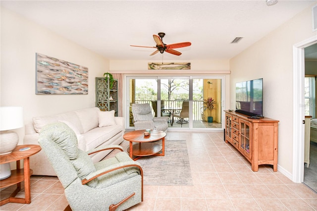 living area featuring light tile patterned floors, baseboards, visible vents, and a ceiling fan