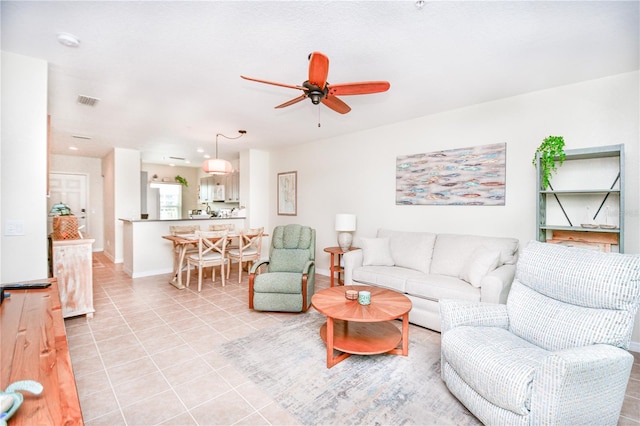 living room featuring visible vents, ceiling fan, and light tile patterned floors