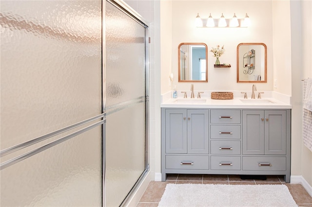 full bath featuring a stall shower, tile patterned flooring, a sink, and double vanity