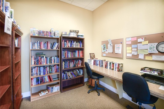 carpeted office with a drop ceiling and baseboards