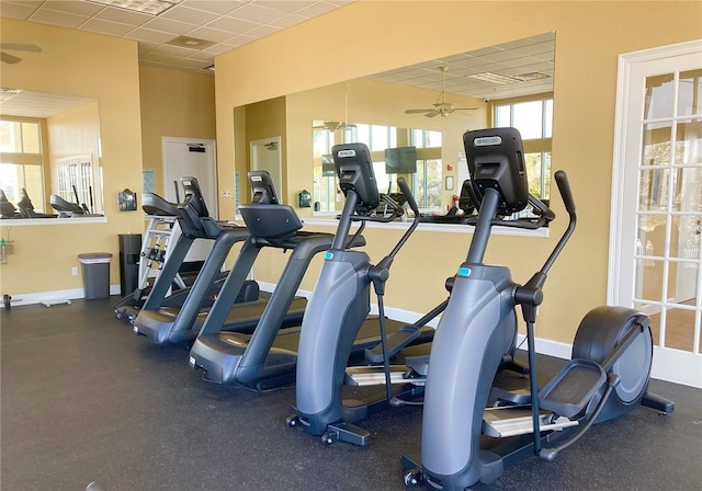 exercise room featuring ceiling fan, baseboards, and a drop ceiling