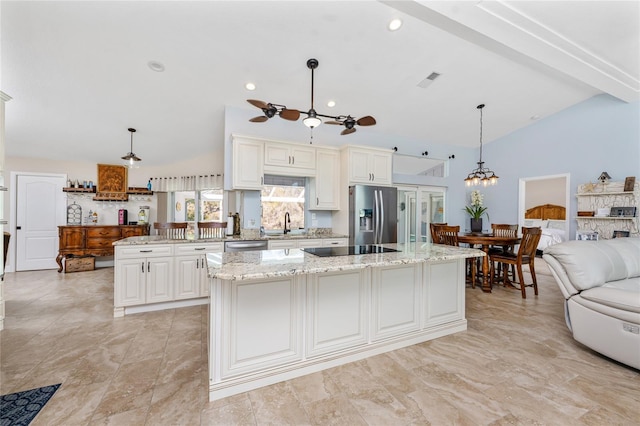 kitchen with open floor plan, a center island, stainless steel appliances, light stone countertops, and hanging light fixtures