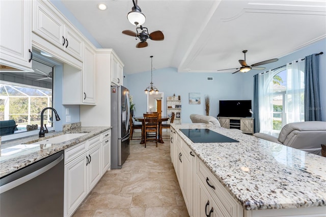 kitchen featuring ceiling fan with notable chandelier, a sink, plenty of natural light, open floor plan, and stainless steel appliances