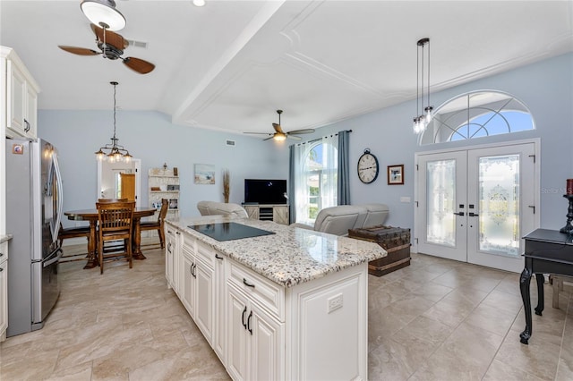 kitchen featuring a ceiling fan, freestanding refrigerator, french doors, pendant lighting, and a center island