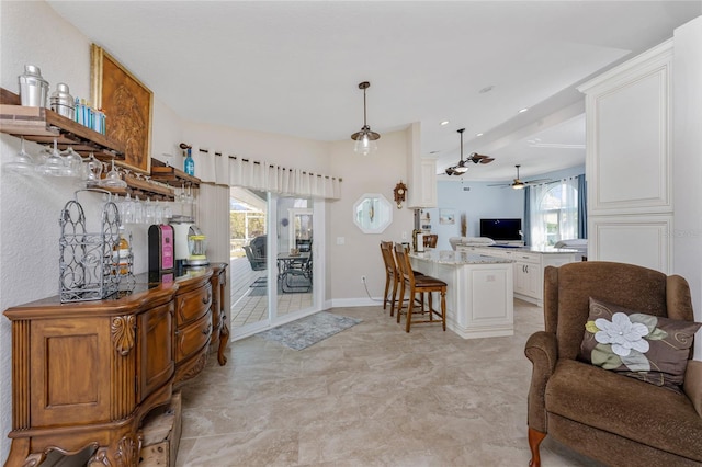 interior space with a ceiling fan and baseboards