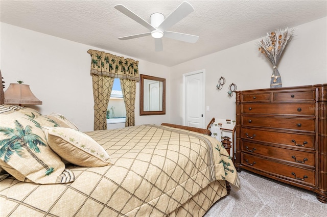 carpeted bedroom featuring a textured ceiling and ceiling fan