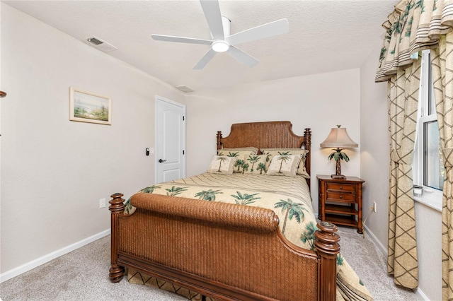 carpeted bedroom featuring visible vents, baseboards, a textured ceiling, and ceiling fan