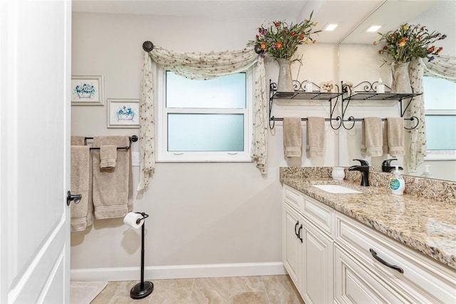 bathroom with vanity, baseboards, and tile patterned flooring