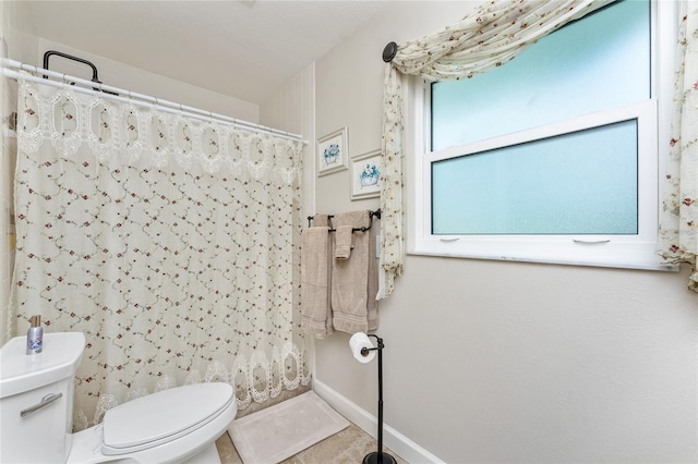 bathroom with tile patterned flooring, toilet, and a shower with shower curtain