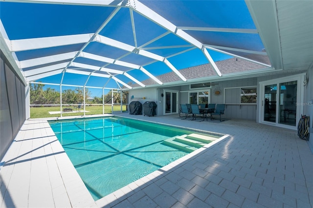 outdoor pool featuring a lanai, a ceiling fan, and a patio