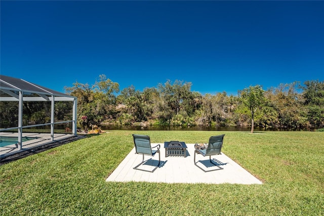 view of yard with a lanai, a patio area, an outdoor pool, and an outdoor fire pit