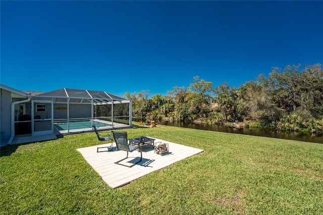 view of yard with glass enclosure, an outdoor pool, an outdoor fire pit, and a patio