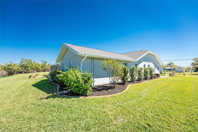 view of side of property featuring stucco siding and a lawn