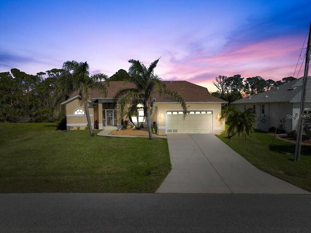 single story home with driveway, stucco siding, an attached garage, and a front yard