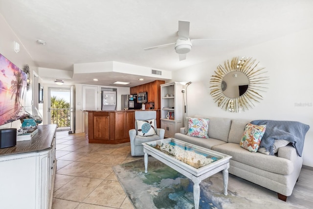 living area with light tile patterned floors, ceiling fan, and visible vents